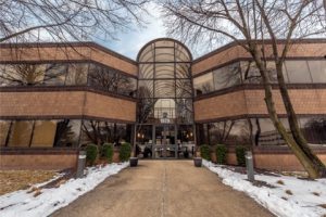 A large three story entrance made of glass to a brick building representing how we offer Naperville individual therapy sessions.